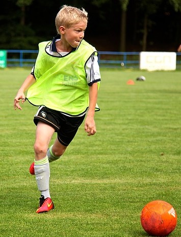 Un Jeune Footballeur Pose Les Exercices D'échelle Pour L